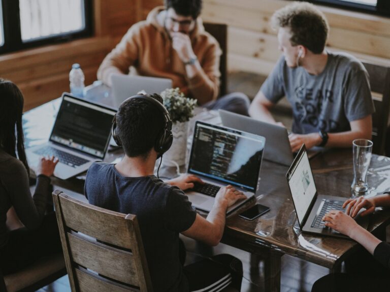 Students sat around a table with their laptops