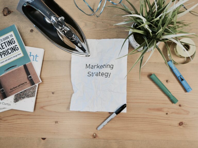 Pens and papers cover a table in a marketing strategy session.