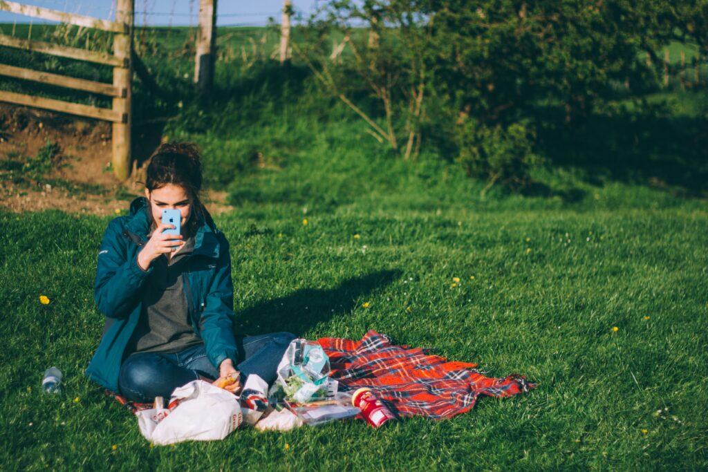 a girl on facetime sat in a field 