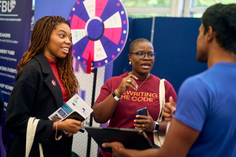 rewriting the code brand rep talking to students at a freshers fair.