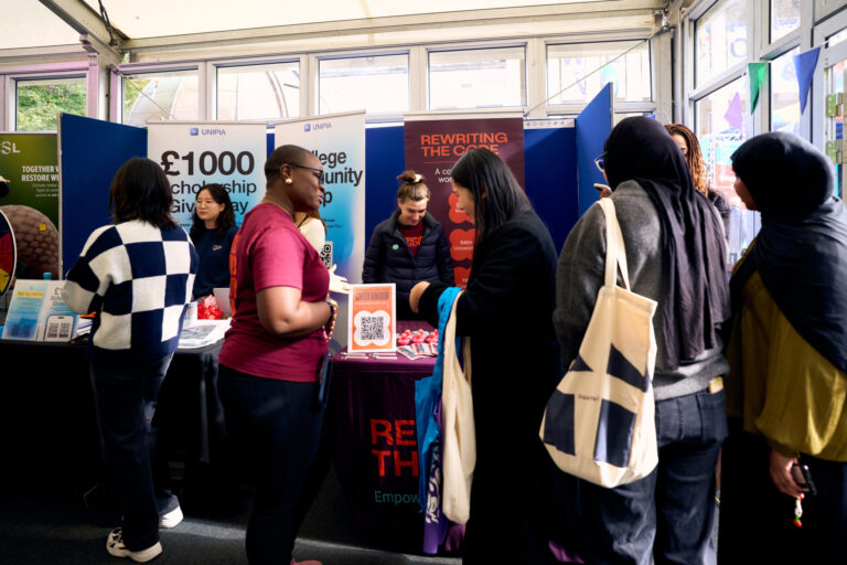 rewriting the code brand rep talking to students at a freshers fair.