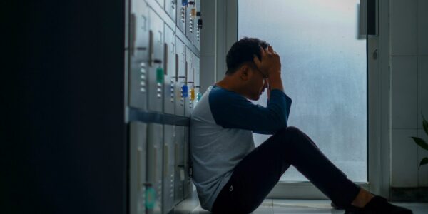 student holding his head in his hands